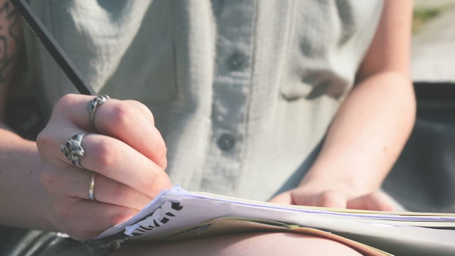 Close up of a young creative designer drawing on a sketchbook with pencil handhold – imagination, creativity concept