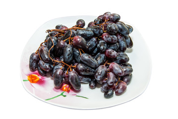 dark blue grapes on plate isolated on white