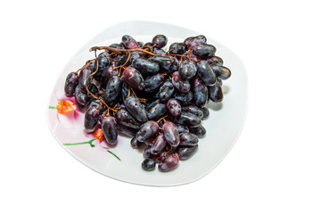 dark blue grapes on plate isolated on white