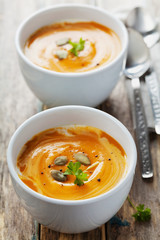 Fresh carrot soup in white bowl, dietary vegetable soup, rustic style