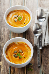 Fresh carrot soup in white bowl, dietary vegetable soup, rustic style