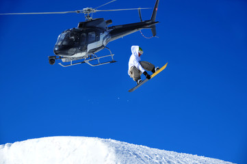 filming a  snowboarder jumping, from a sports helicopter