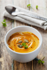 Fresh carrot soup in white bowl, dietary vegetable soup, rustic style