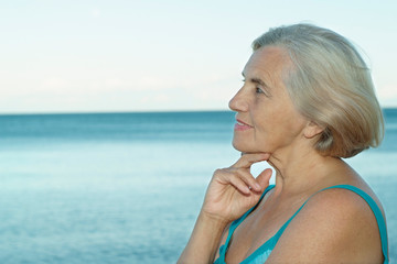 Happy elderly woman on beach