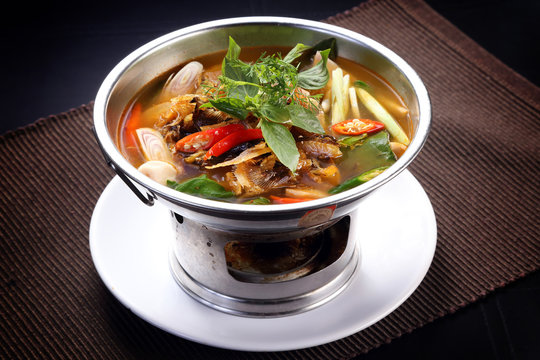 Sour and Spicy Smoked Dry Fish Soup in hot pot, isolated