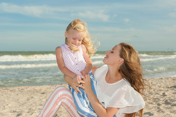 Mother and daughter having fun playing on the beach
