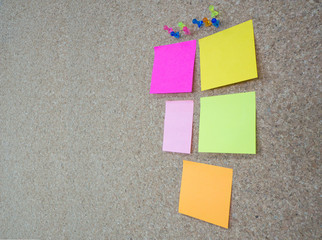 Group of thumbtacks pinned and colorful memorandum notes on cork