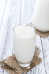 Milk on bright wooden background