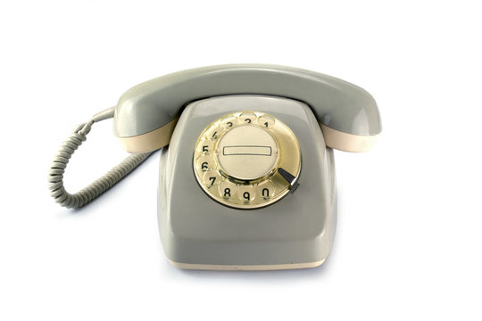 Vintage rotary phone, gray yellowed plastic  on a white backgrou