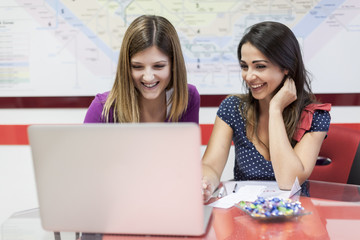 Due giovani studentesse mentre lavorano al pc