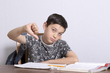 Young Boy Giving Thumbs Down Over Homework