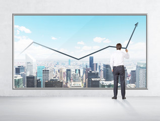 Rear view of businessman who is drawing a line chart on the New York panoramic poster. Concrete wall.