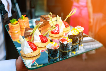 Server holding a tray of appetizers at banquet. Toned image