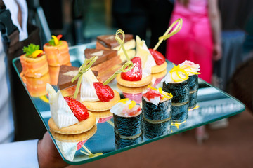 Server holding a tray of appetizers at banquet.