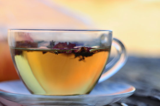 glass cup and saucer with herbal tea and a blurred background