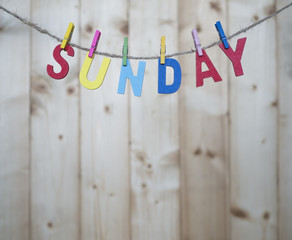 Weekdays 1 - Sunday word by wooden letters hang with rope on wood background (Weekdays word series)