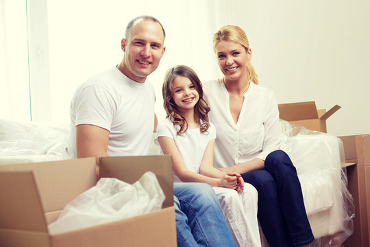happy family with boxes moving to new home