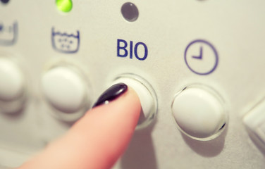 close up of woman finger pressing washer button