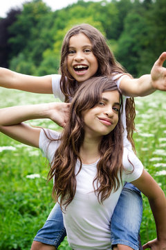 Portrait of two girls messing about in the countryside