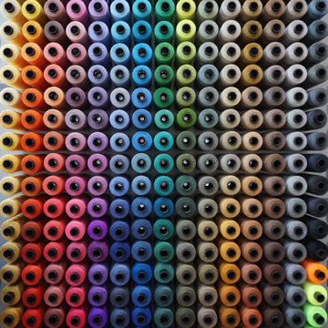 Full frame close-up of rows of multi coloured sewing thread