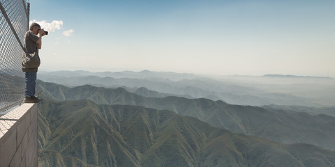 Man taking photo of mountain range