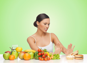 woman with fruits rejecting hamburger