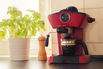 A red vintage looking espresso coffee machine in kitchen