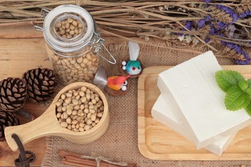 Fototapeta na wymiar Tofu and soybeans on wood background.