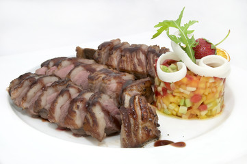 goose breast with vegetables on a white plate