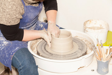 Female Potter creating a earthen jar on a Potter's wheel