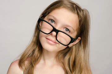 Beautiful little girl wearing big eyeglasses and looking smart