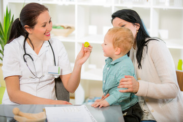 Young woman and her child at the doctor homeopaths. Treatment with herbs. Doctor gives homeopathic...