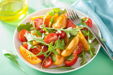 tomato salad with arugula over green background