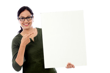 Cheerful young woman holding empty white board - 95478198