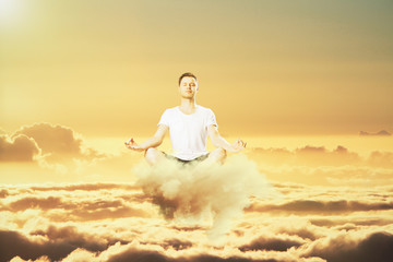 Fototapeta na wymiar Man meditation in the clouds concept