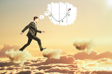 Man thinking about business graph and walking on clouds concept