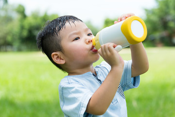 Cute boy drinking water with bottle