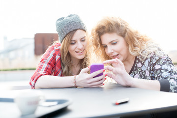 Two young curly and straight blonde hair woman