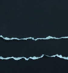 Torn pieces of paper on black background