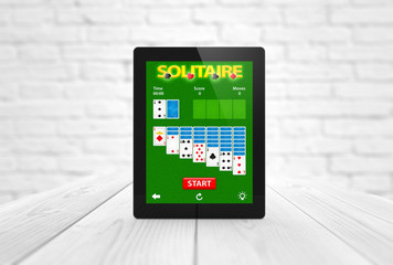 solitaire game app tablet on wooden table