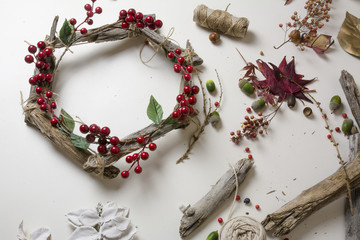 Florist at work: Creating a wooden wreath with christmas  red barries