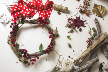 Florist at work: Creating a wooden wreath with christmas  red barries