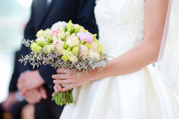 Obraz na płótnie Canvas Bride holding a beautiful wedding bouquet
