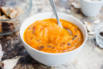 Autumn pumpkin soup in a white plate, healthy lunch