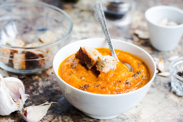 Autumn pumpkin soup in a white plate, healthy lunch