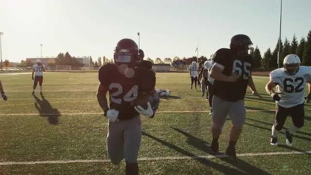 A football player makes a touchdown in slow motion
