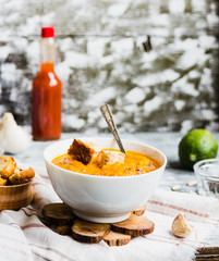 Pumpkin soup with carrots, croutons in a white dish, vegetarian,