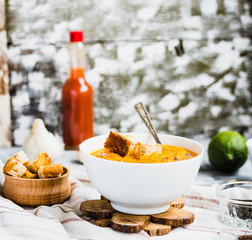 Pumpkin soup with carrots, croutons in a white dish, vegetarian