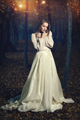 Fototapeta premium Beautiful victorian dressed woman in fairy forest