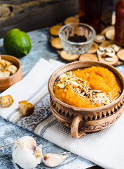 Pumpkin soup with carrots and homemade croutons in clay pots, ru